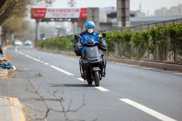 为大风中的外卖骑手系上“安全带”
